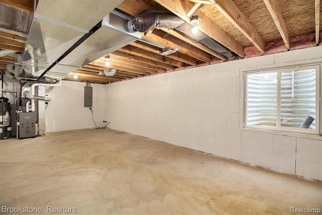 below grade area featuring electric panel, gas water heater, and heating unit