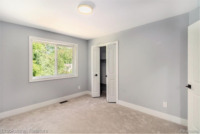 unfurnished bedroom with carpet, visible vents, a closet, and baseboards