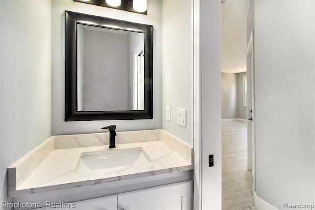 bathroom featuring baseboards, wood finished floors, and vanity