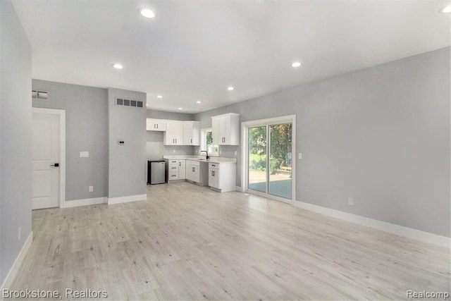 unfurnished living room featuring recessed lighting, visible vents, light wood-style flooring, and baseboards