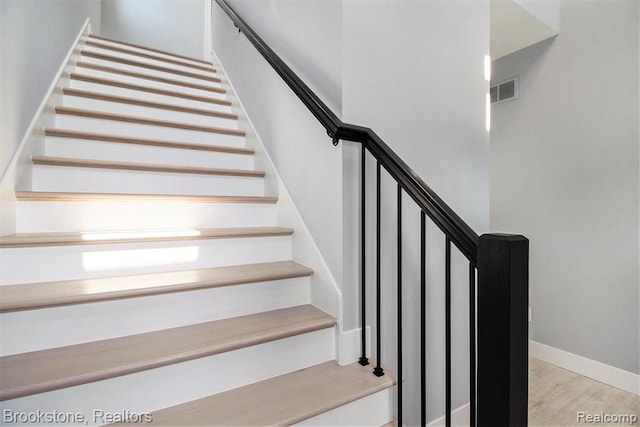 stairs with baseboards and wood finished floors