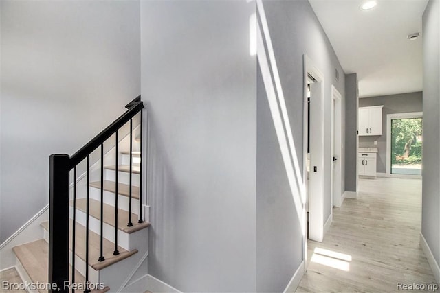 staircase featuring recessed lighting, baseboards, and wood finished floors