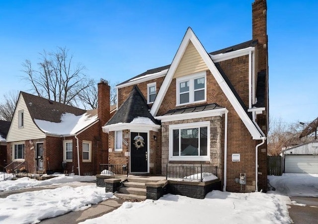 tudor home featuring brick siding and a chimney