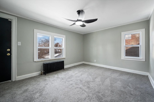 carpeted spare room featuring ornamental molding, radiator, baseboards, and a ceiling fan