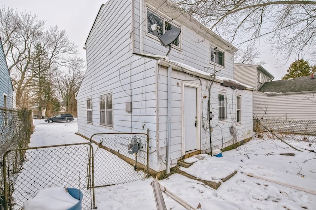 view of snow covered exterior with fence