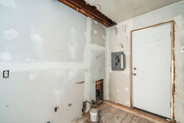 laundry area featuring electric panel and light wood-style floors