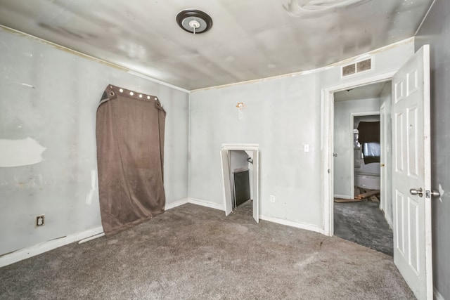 spare room featuring carpet flooring, visible vents, and baseboards