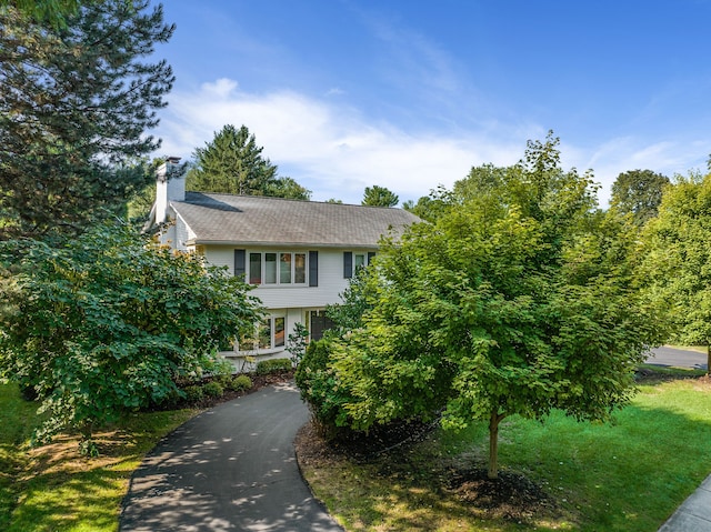 view of front facade with driveway and a chimney