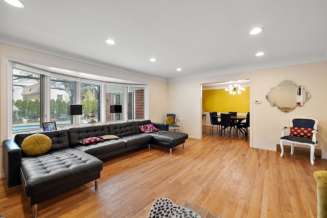 living room featuring an inviting chandelier, light wood-style flooring, baseboards, and recessed lighting