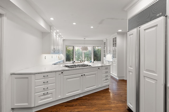 kitchen featuring stainless steel gas cooktop, hanging light fixtures, glass insert cabinets, white cabinetry, and a peninsula