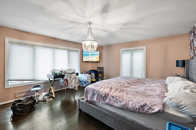 bedroom with a chandelier, dark wood finished floors, and baseboards