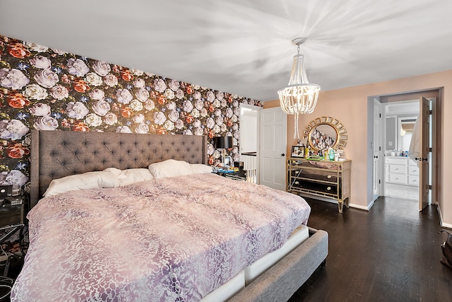 bedroom with dark wood-style floors, an accent wall, a chandelier, baseboards, and wallpapered walls