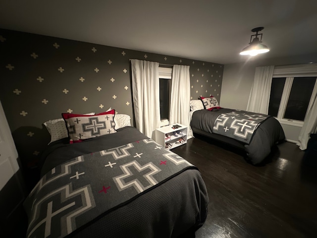 bedroom with dark wood-style floors and wallpapered walls