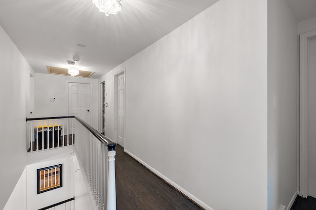 corridor featuring an upstairs landing, dark wood finished floors, and baseboards