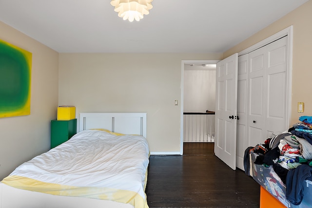 bedroom with dark wood-style flooring, a closet, and baseboards