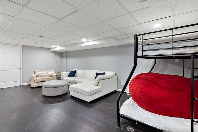 bedroom featuring baseboards, a drop ceiling, wood finished floors, and recessed lighting