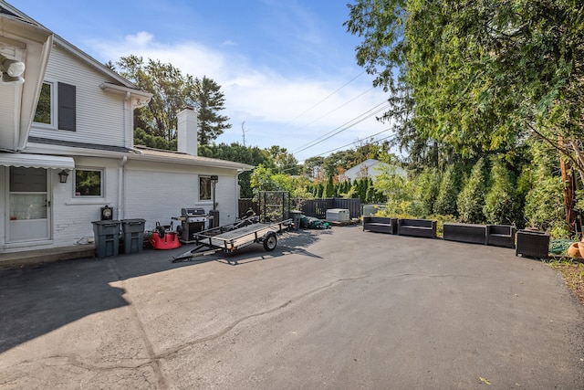 view of patio featuring a grill, fence, and an outdoor living space