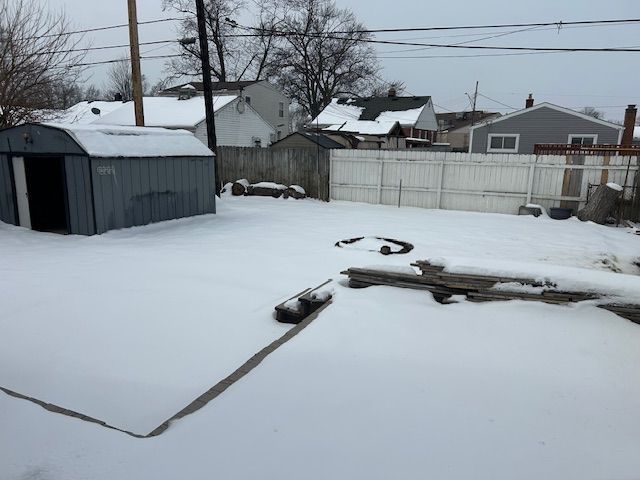 yard layered in snow with fence