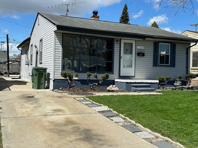bungalow featuring a chimney and a front yard