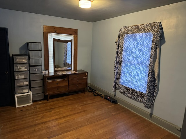 bedroom with baseboards and wood finished floors