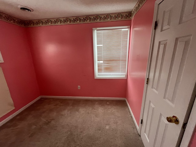 empty room featuring carpet floors, baseboards, and a textured ceiling