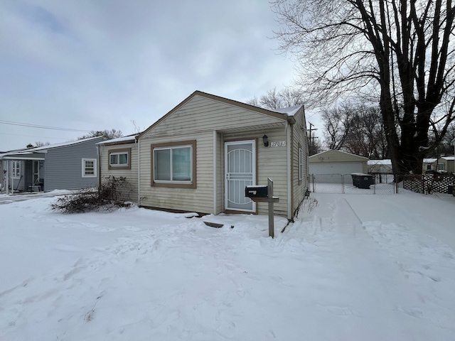 view of front of property with a detached garage and fence