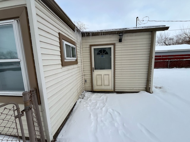 snow covered property entrance featuring fence