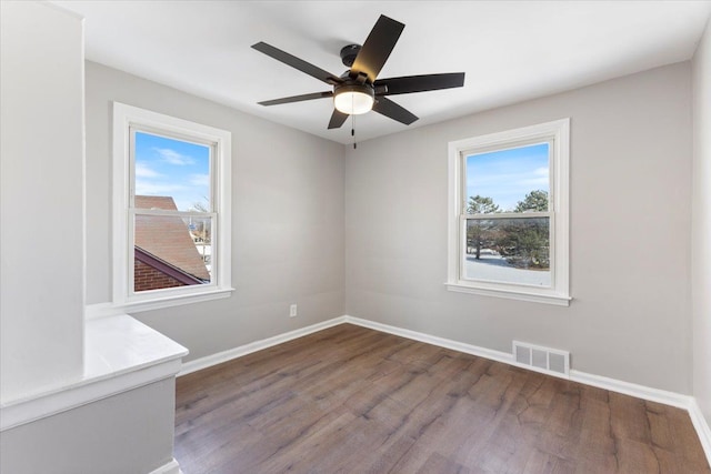 unfurnished room with visible vents, plenty of natural light, and baseboards