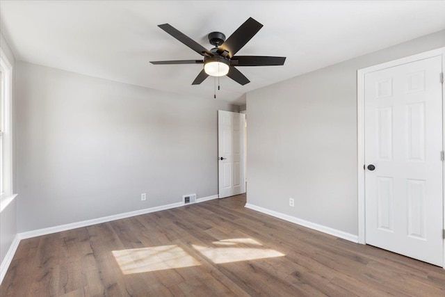 interior space featuring ceiling fan, wood finished floors, visible vents, and baseboards