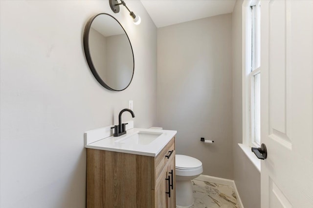 bathroom featuring marble finish floor, vanity, toilet, and baseboards