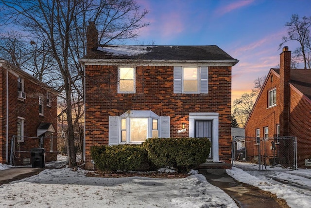 colonial house with fence and brick siding