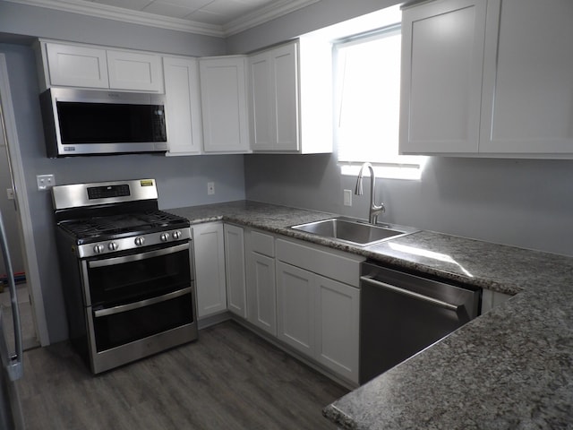 kitchen with dark wood finished floors, crown molding, stainless steel appliances, white cabinets, and a sink