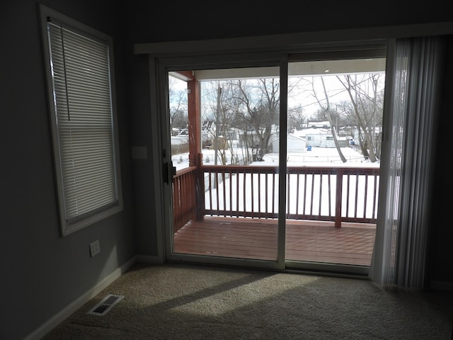 doorway to outside featuring carpet flooring, visible vents, and baseboards