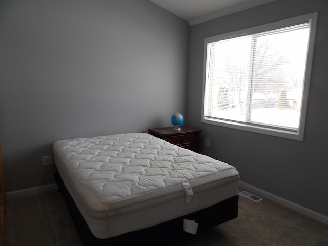 bedroom with ornamental molding, baseboards, visible vents, and carpet flooring