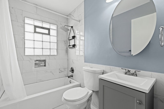 bathroom with a wainscoted wall, tile walls, shower / bath combination with curtain, toilet, and vanity