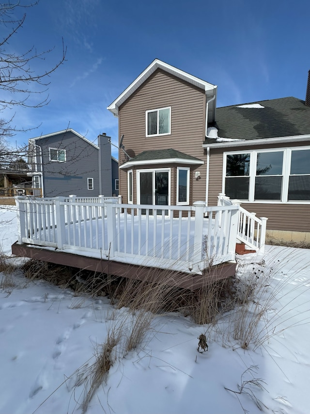 snow covered house with a deck