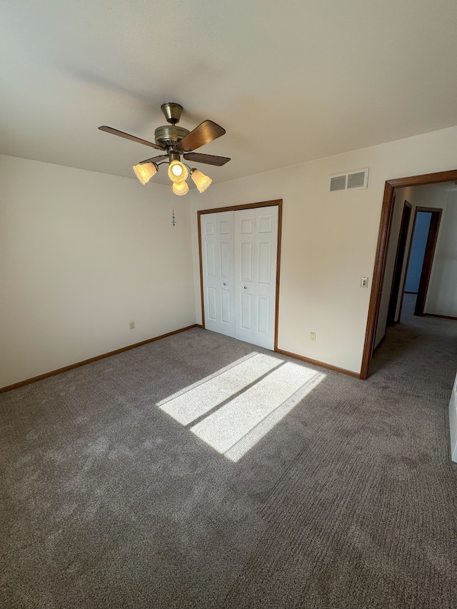 unfurnished bedroom with carpet floors, baseboards, visible vents, and a closet