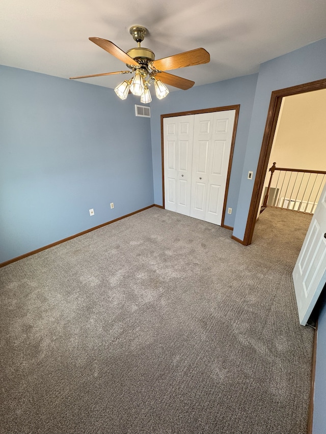 unfurnished bedroom featuring baseboards, visible vents, ceiling fan, carpet, and a closet