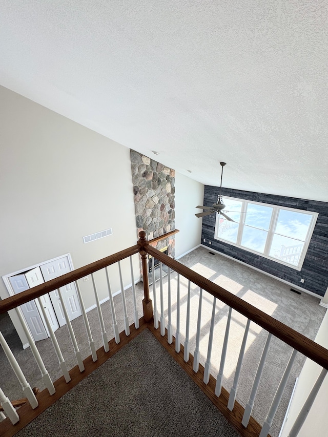 stairs featuring a textured ceiling, visible vents, and a ceiling fan