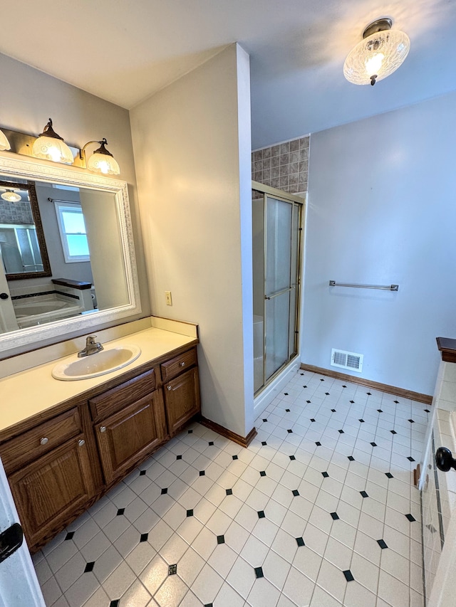 full bath featuring a stall shower, baseboards, visible vents, and vanity