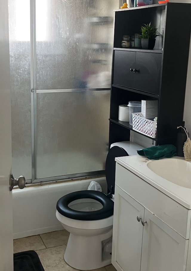 bathroom featuring bath / shower combo with glass door, vanity, toilet, and tile patterned floors