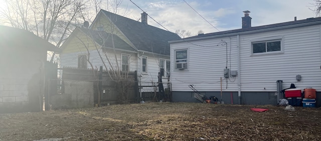 rear view of property featuring fence