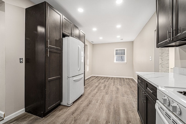 kitchen with light stone counters, recessed lighting, baseboards, light wood-type flooring, and freestanding refrigerator