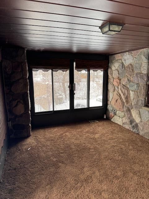 unfurnished room with carpet and wooden ceiling