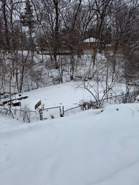 yard covered in snow featuring fence