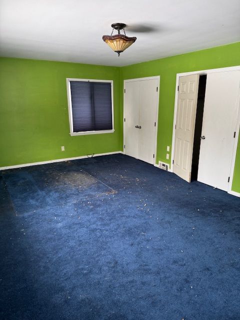 carpeted spare room featuring baseboards