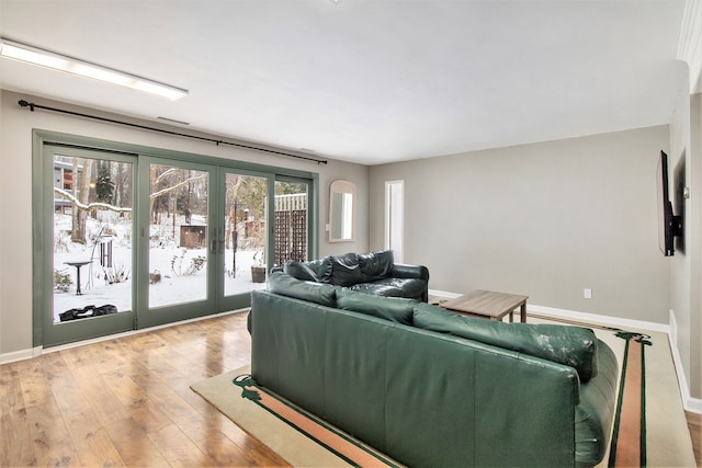 living room featuring wood-type flooring, baseboards, and french doors