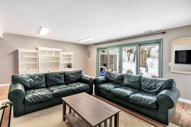 living room featuring french doors, visible vents, baseboards, and wood finished floors