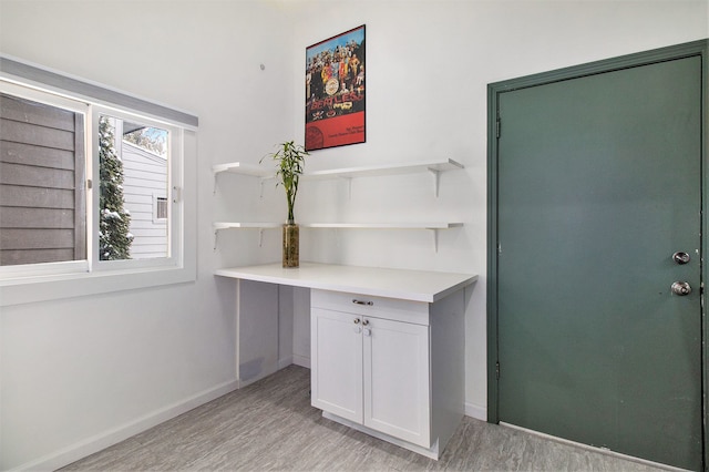 interior space featuring baseboards and light wood-style flooring