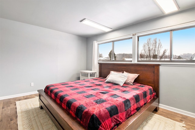 bedroom with baseboards and wood finished floors